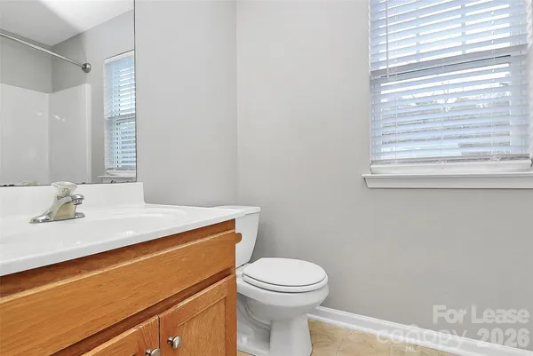 a bathroom with a sink a toilet and a window