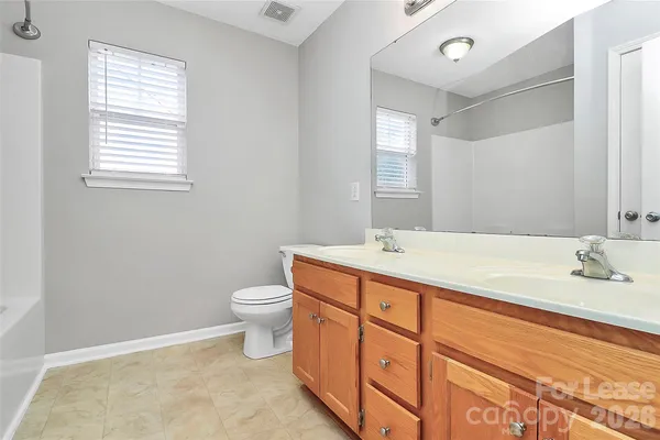 a bathroom with a double vanity sink toilet and a mirror