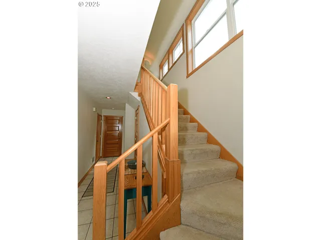 a view of staircase with railing and white walls