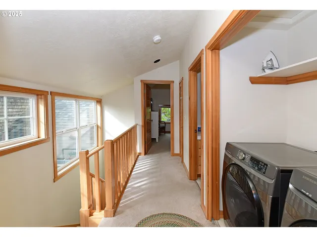 a view of a hallway with wooden floor and staircase