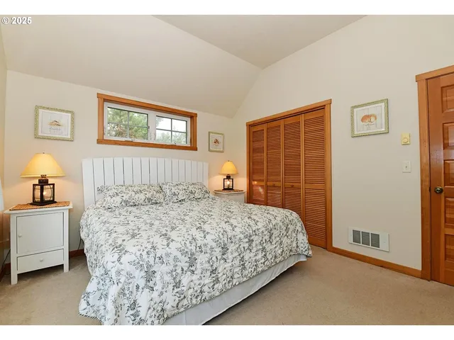 a bedroom with a bed and a lamp on dresser