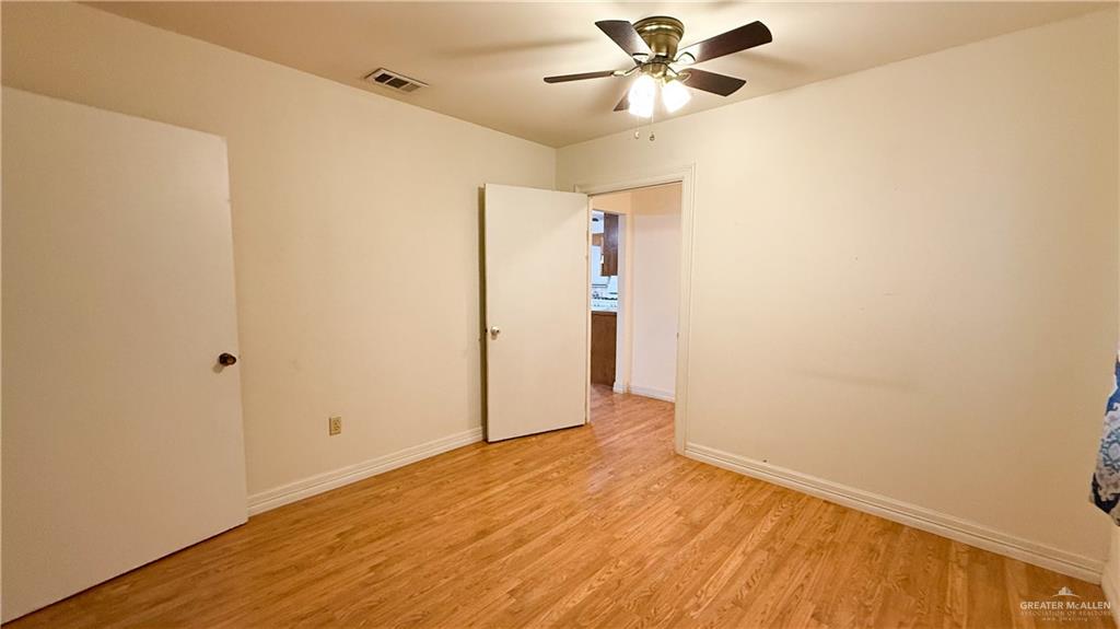 21713 North Western Road Edinburg, TX 78541 - Photo 12 of 24 Empty room with light wood-style floors and ceiling fan