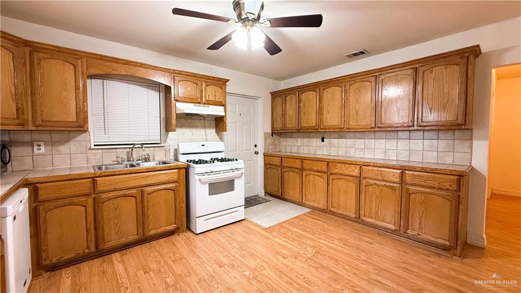 21713 North Western Road Edinburg, TX 78541 - Photo 3 of 24 Kitchen with white appliances, wood finish cabinets, ceiling fan, and light wood-style flooring