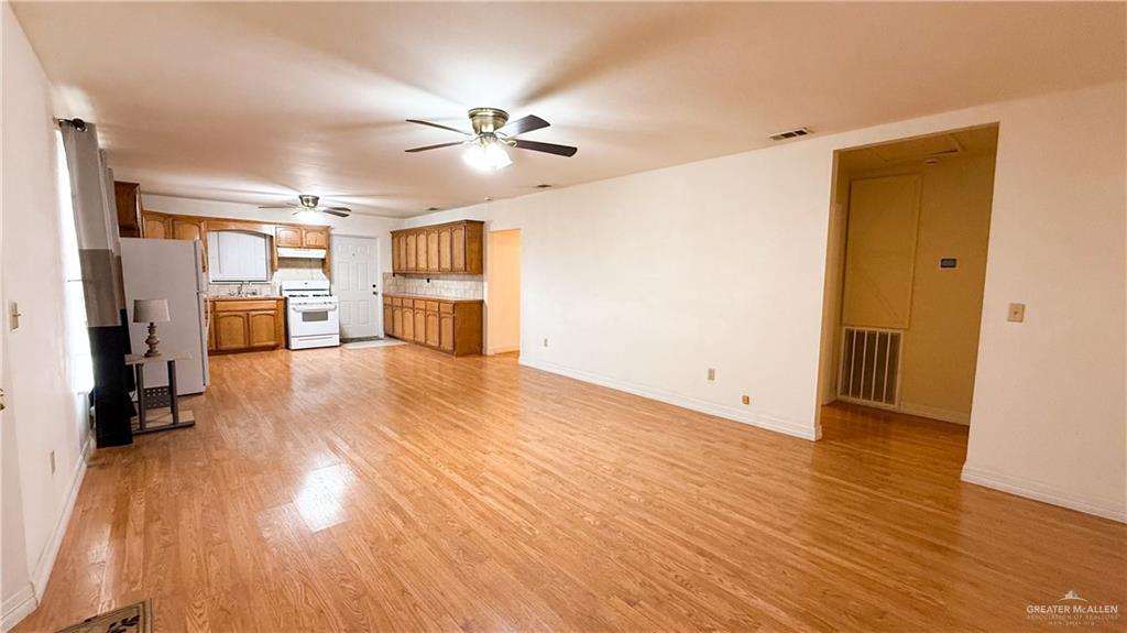 21713 North Western Road Edinburg, TX 78541 - Photo 5 of 24 Unfurnished living room featuring light wood-type flooring and ceiling fan