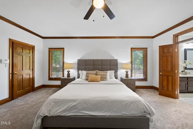 a bedroom with a large bed and a chandelier