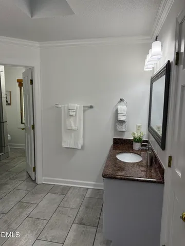 a bathroom with a granite countertop sink a mirror and shower