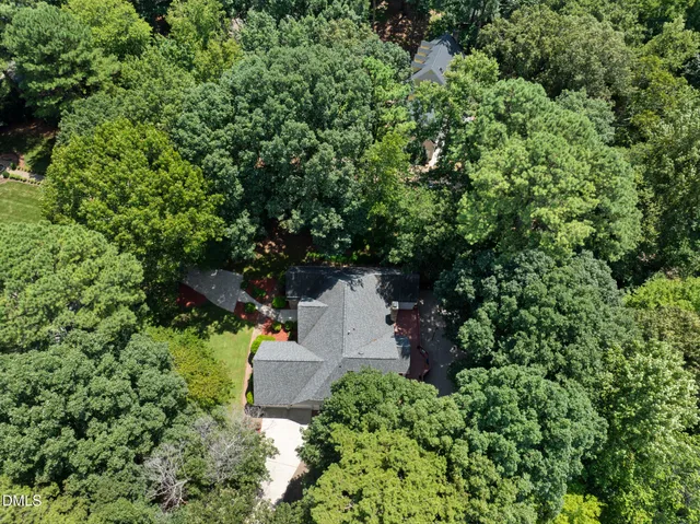 an aerial view of residential house with outdoor space and trees all around