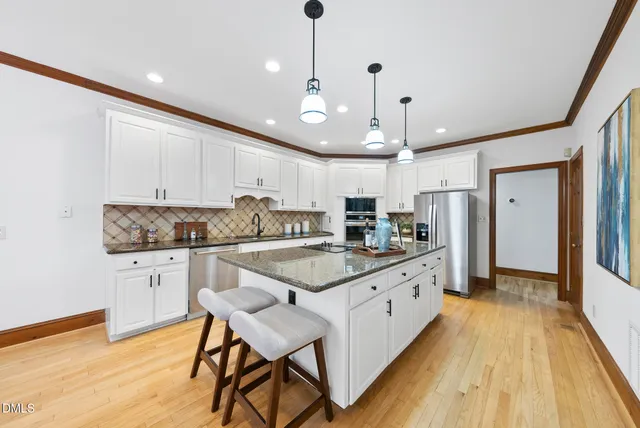 a kitchen with stainless steel appliances granite countertop a sink and a refrigerator