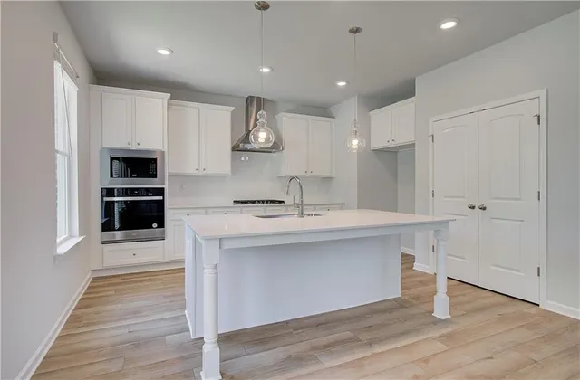 a kitchen with kitchen island a sink and a stove top oven