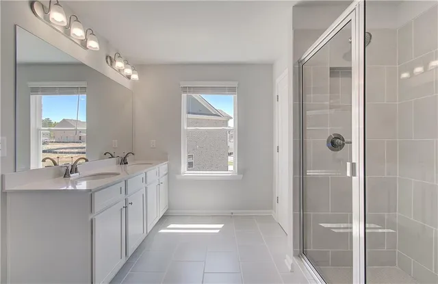 a bathroom with a double vanity sink a large mirror and a shower
