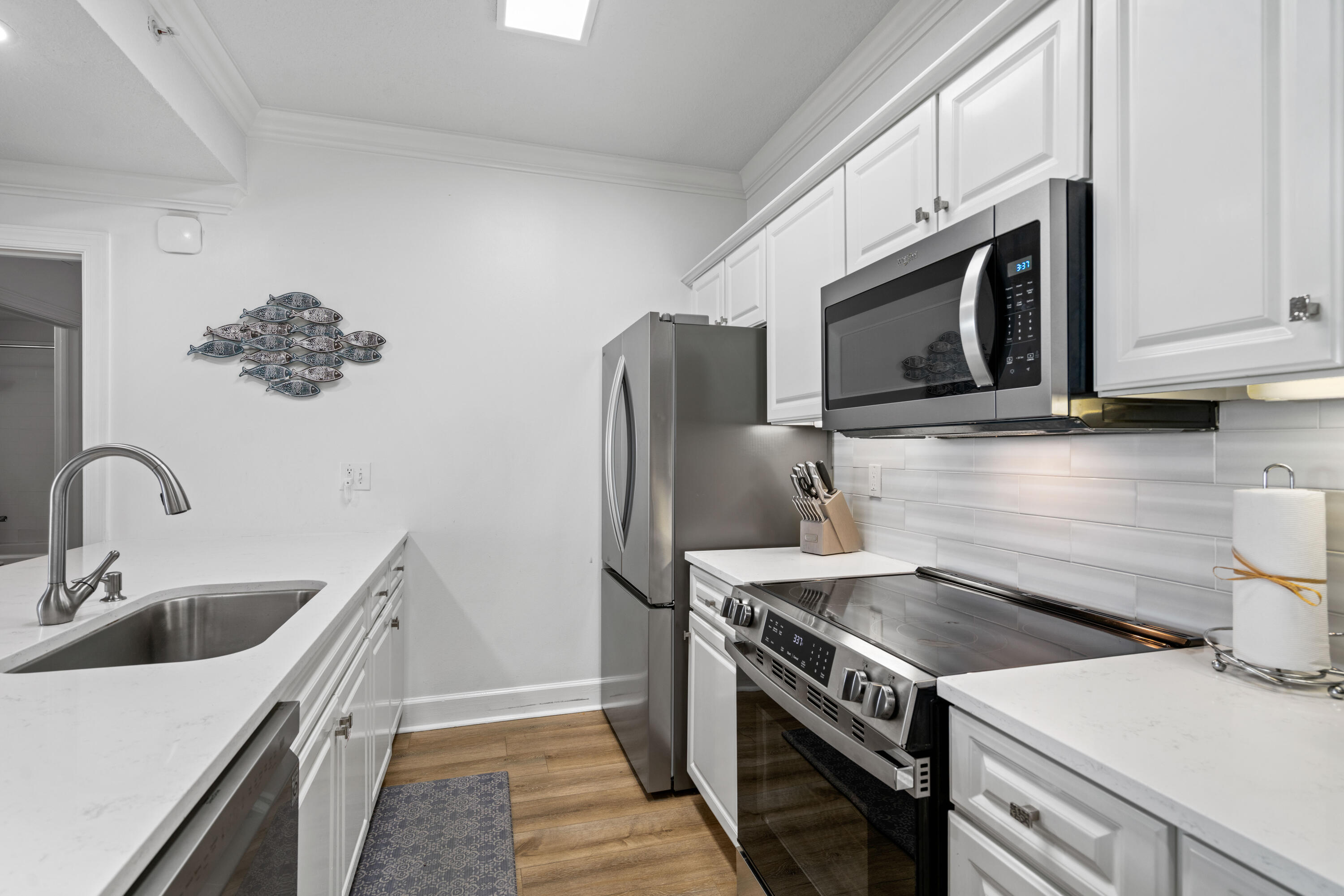 10611 Front Beach Road, Unit 303 Panama City Beach, FL 32408 - Photo 11 of 51 a kitchen with stainless steel appliances a stove microwave sink and refrigerator