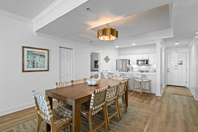 a view of a dining room with furniture a chandelier and wooden floor