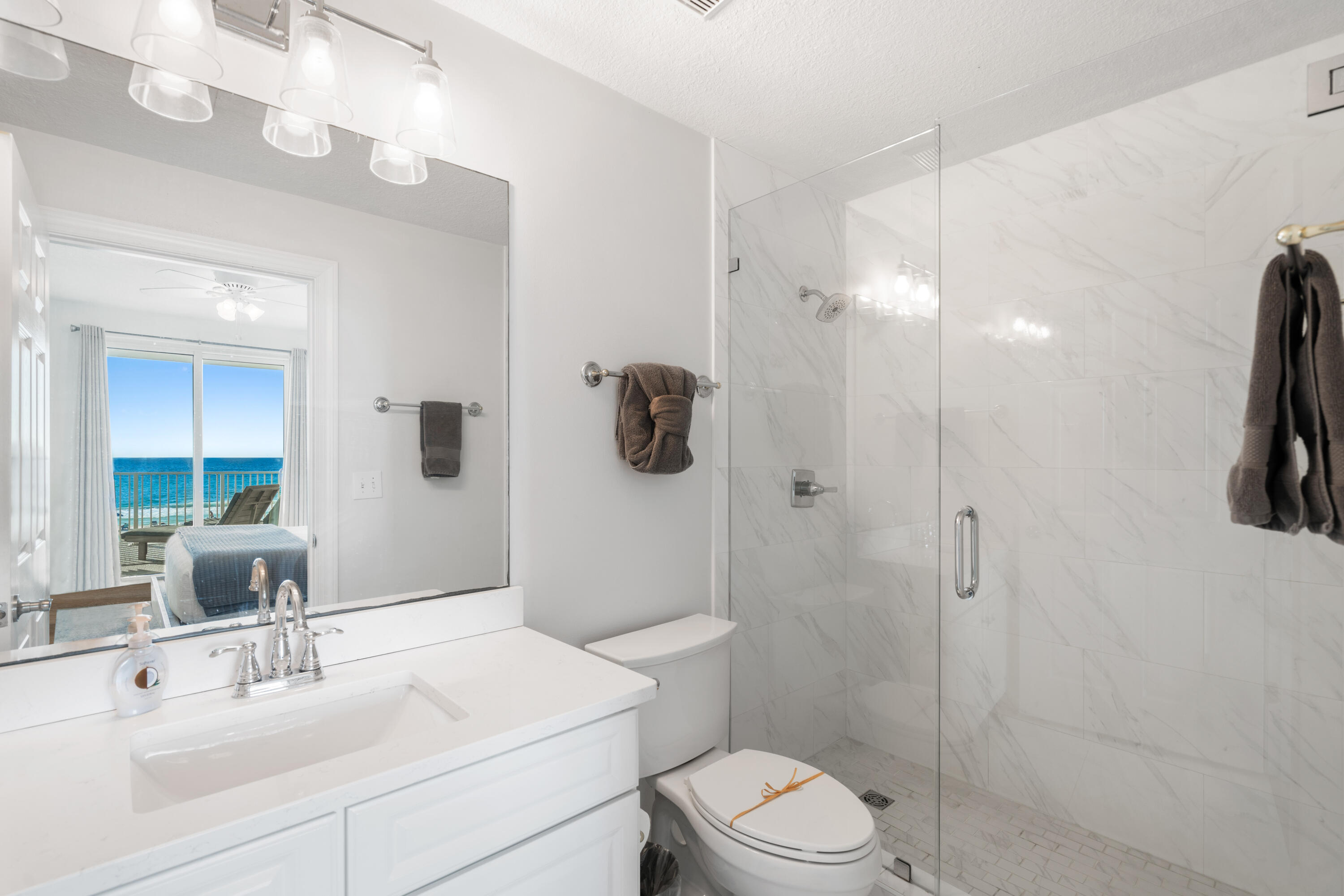 10611 Front Beach Road, Unit 303 Panama City Beach, FL 32408 - Photo 29 of 51 a bathroom with a sink a toilet and shower