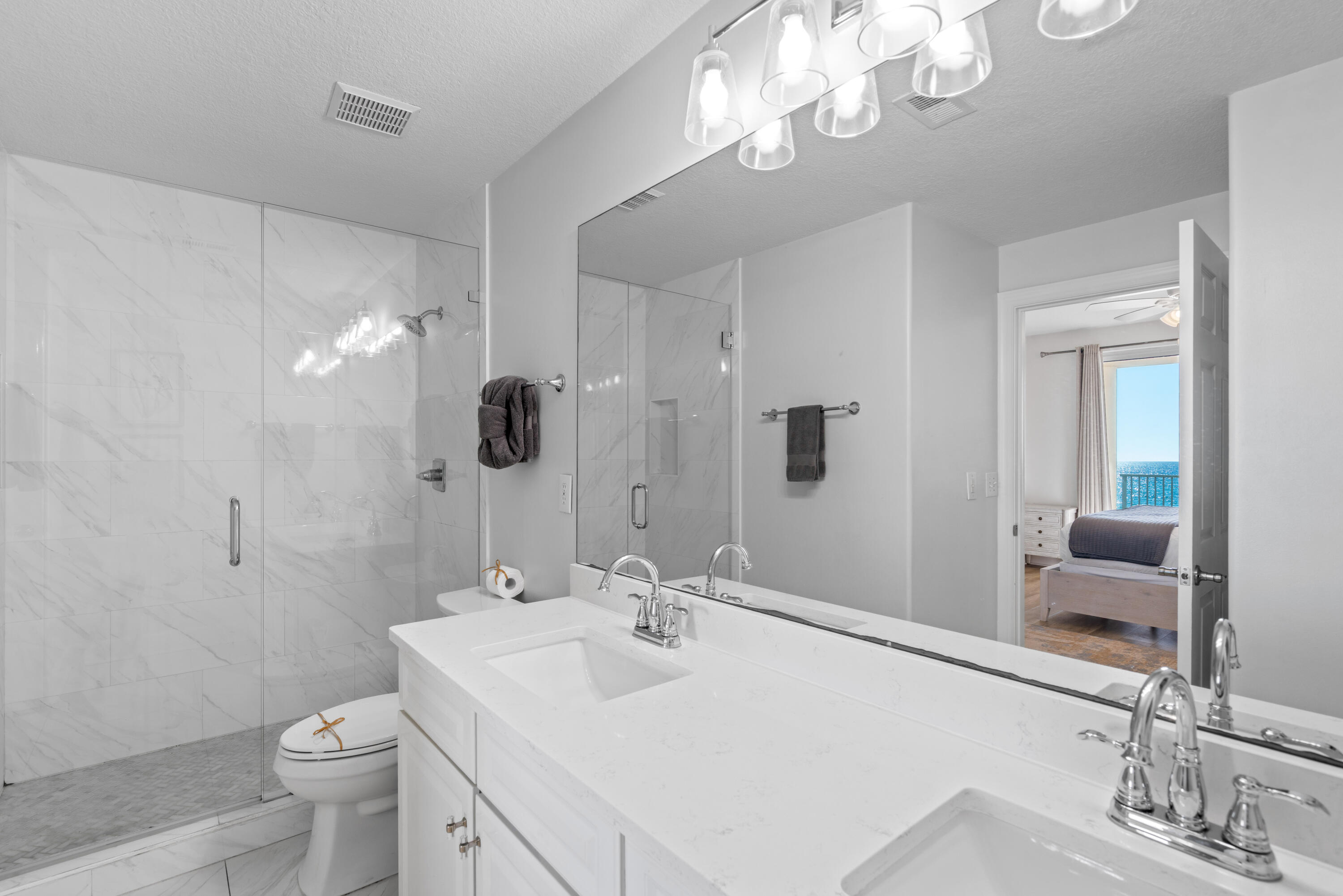 10611 Front Beach Road, Unit 303 Panama City Beach, FL 32408 - Photo 34 of 51 a bathroom with a sink a toilet and a large mirror