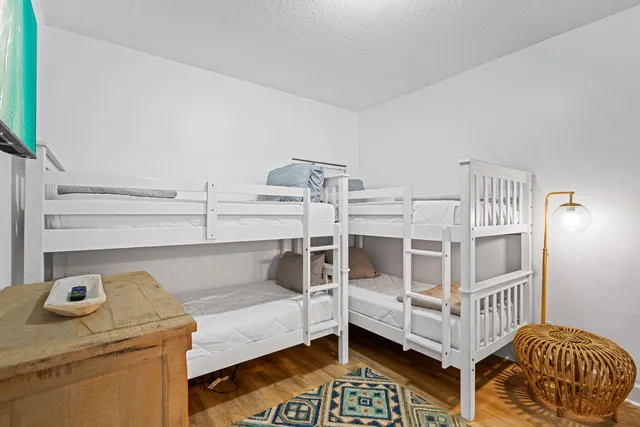 a bedroom with a bed and wooden floor