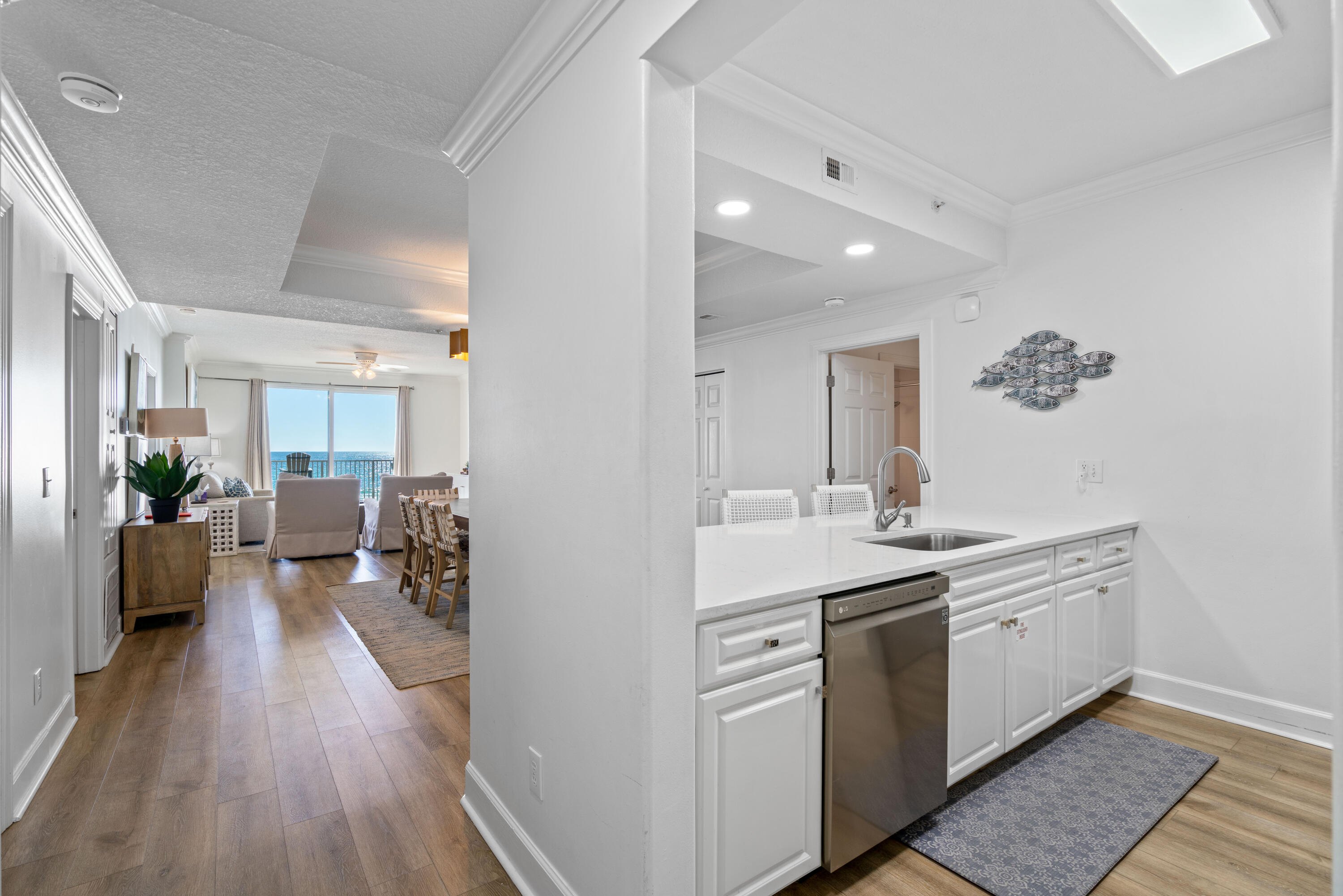 10611 Front Beach Road, Unit 303 Panama City Beach, FL 32408 - Photo 9 of 51 a view of a hallway with wooden floor and furniture
