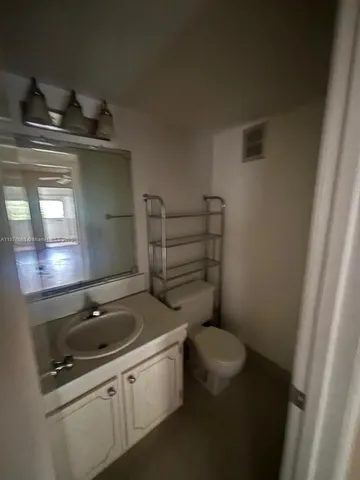 a bathroom with a toilet a sink and mirror