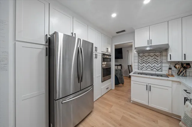 a kitchen with stainless steel appliances a refrigerator sink and cabinets