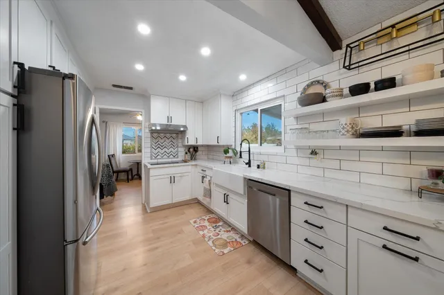 a kitchen with stainless steel appliances a refrigerator sink and cabinets