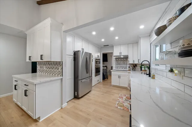 a kitchen with stainless steel appliances a refrigerator sink and cabinets