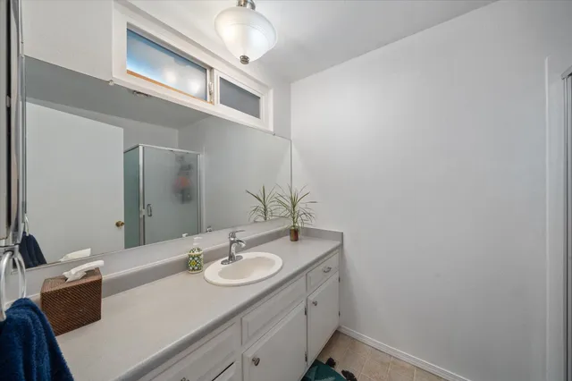 a bathroom with a sink vanity granite and a mirror