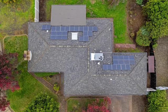 an aerial view of a house with garden space and a yard