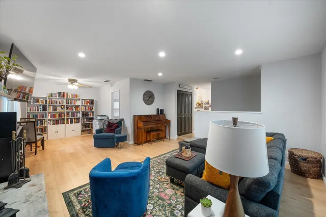 a living room with furniture kitchen view and a wooden floor
