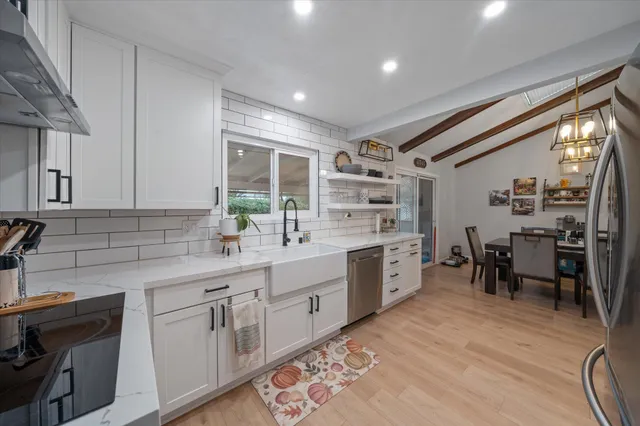 a kitchen with white cabinets and wooden floors