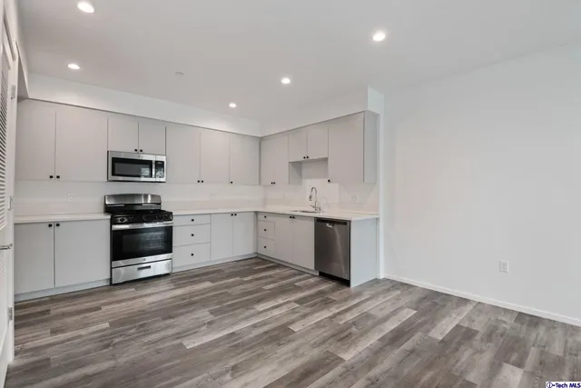 an empty room with wooden floor & closet area