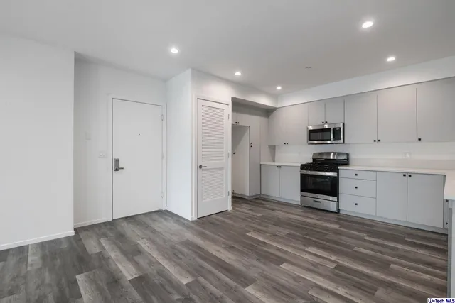 a kitchen with granite countertop white cabinets and stainless steel appliances