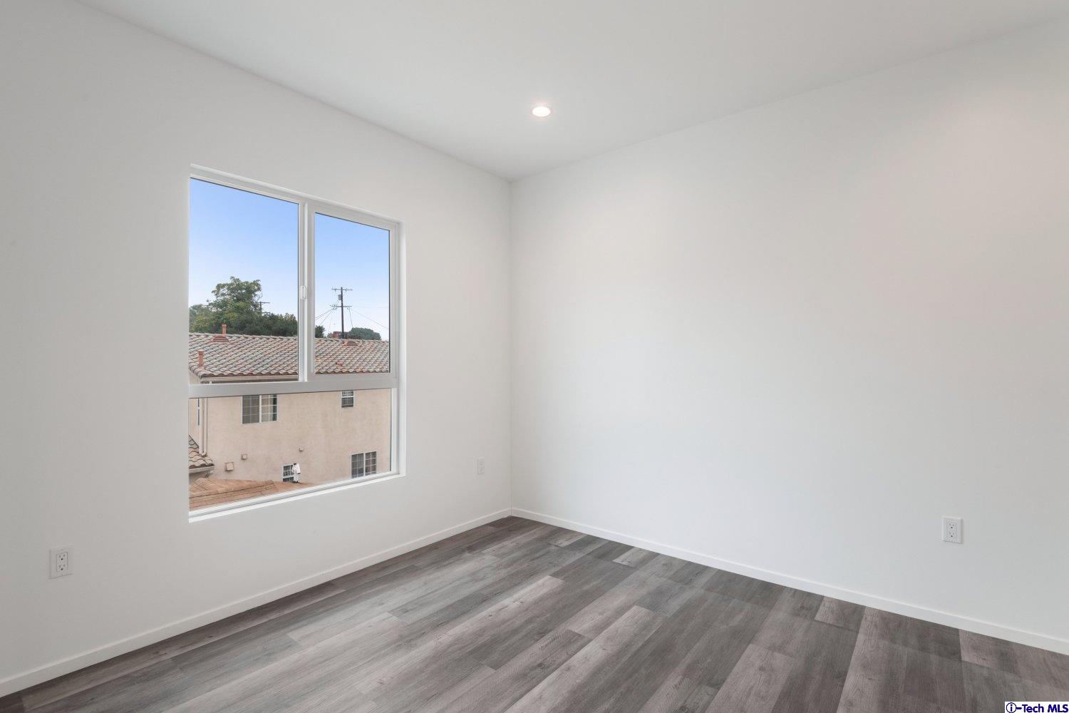 7064 Greeley Street, Unit 202 Tujunga, CA 91042 - Photo 38 of 45 a view of an empty room with wooden floor and a window