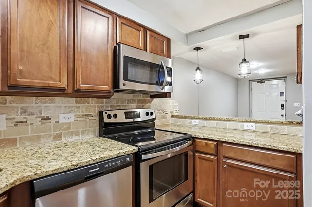 a kitchen with stainless steel appliances granite countertop a refrigerator and a sink