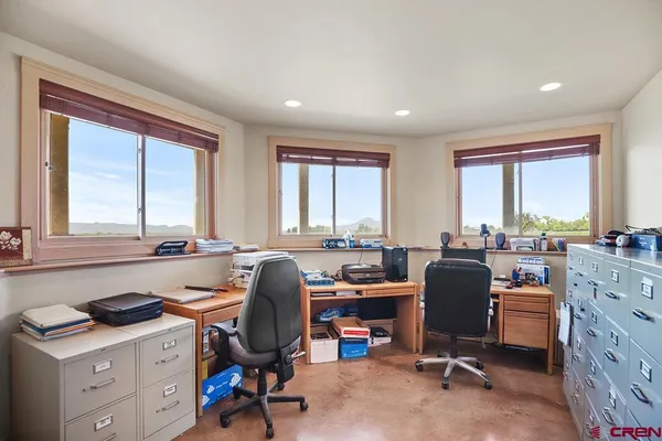 a view of a workspace with furniture and a window