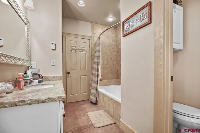 a bathroom with a granite countertop sink a mirror and a bathtub