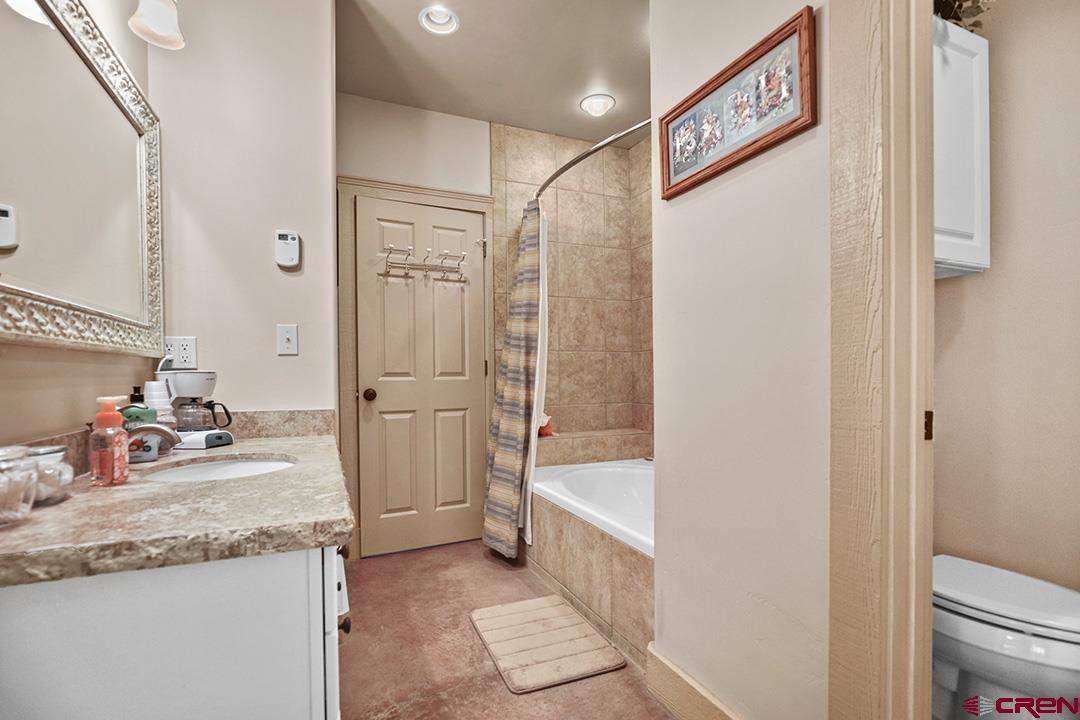 22259 Rd U Cortez, CO 81321 - Photo 23 of 35 a bathroom with a granite countertop sink a mirror and a bathtub