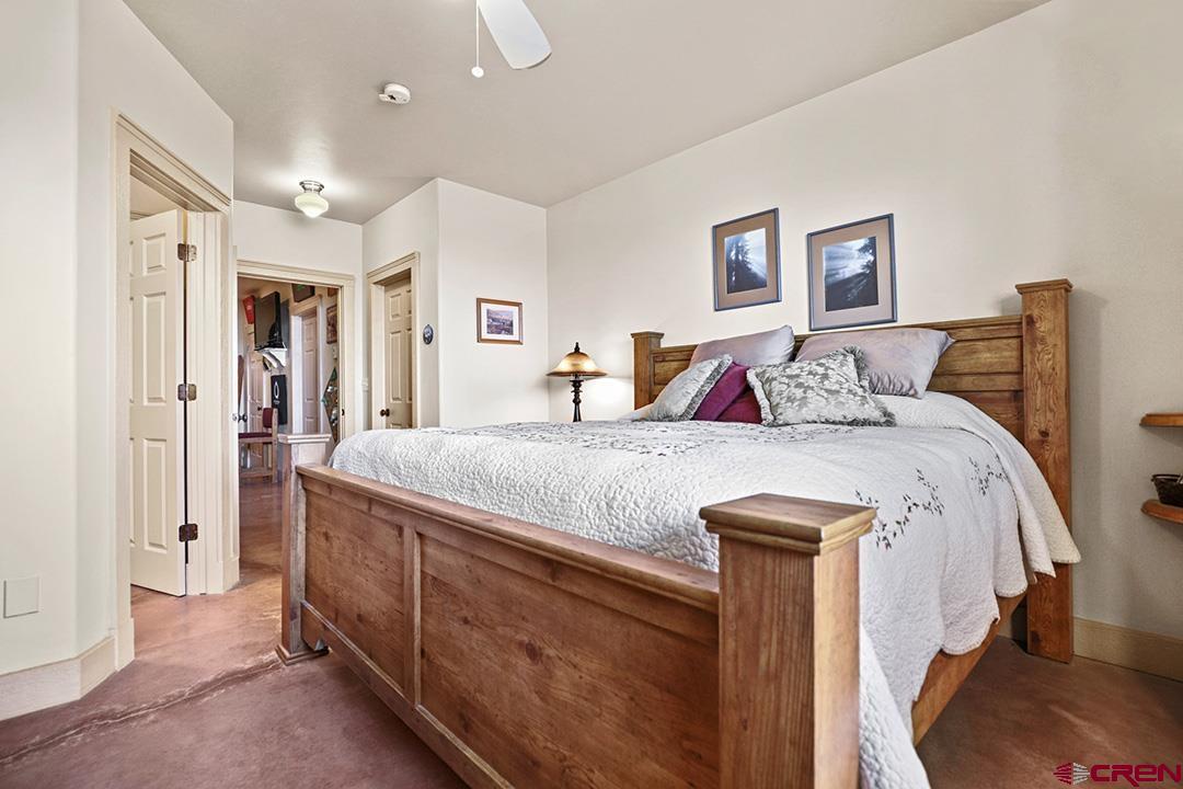 22259 Rd U Cortez, CO 81321 - Photo 24 of 35 a bedroom with a large bed and a chandelier