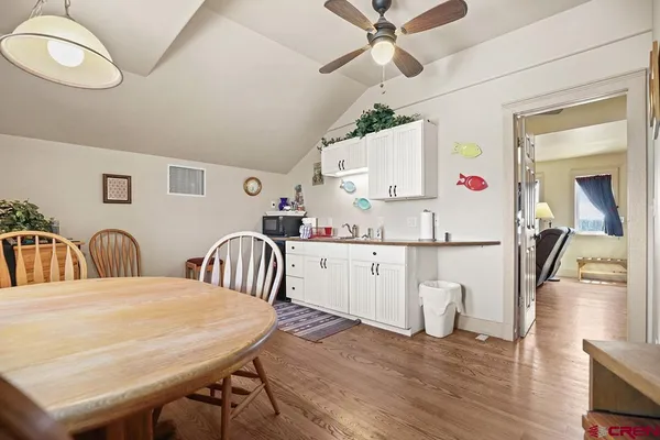 a kitchen with a table chairs and white appliances