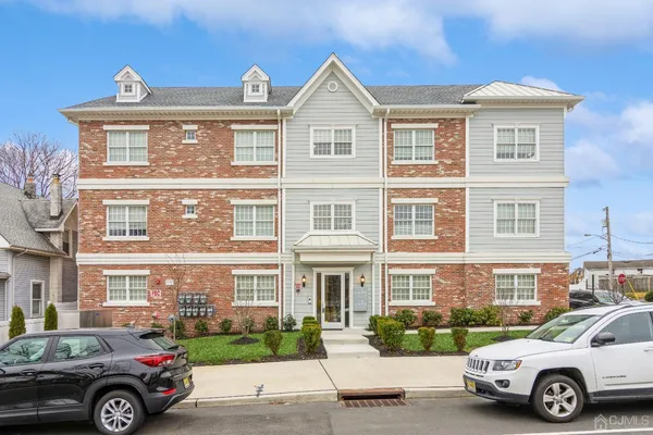 a front view of a house with a yard and parking space