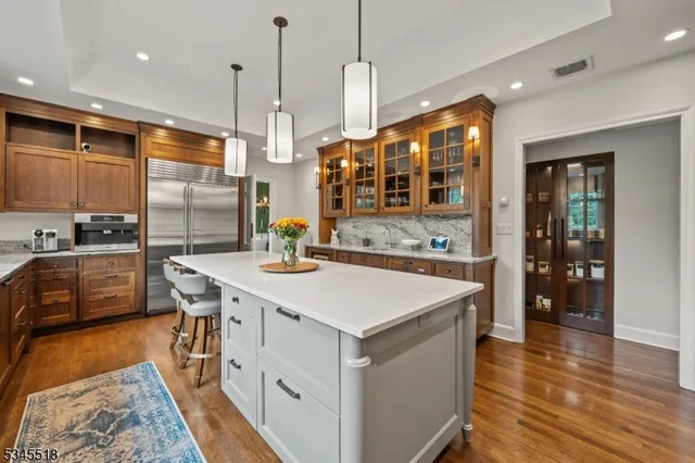 a kitchen with stainless steel appliances granite countertop a sink a stove and a refrigerator