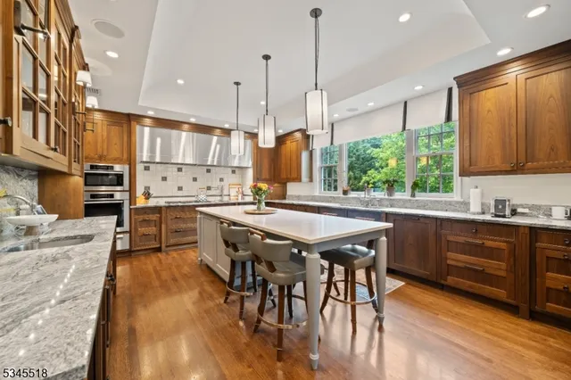 a kitchen with stainless steel appliances granite countertop wooden floors stove and cabinets