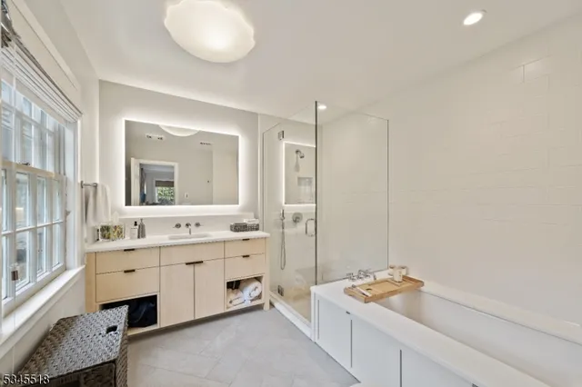 a bathroom with a tub sink and mirror
