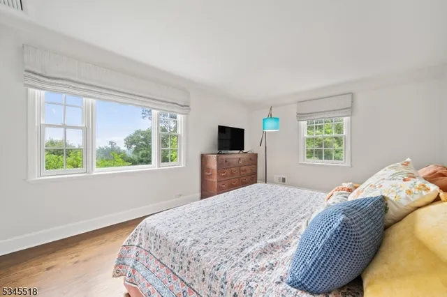 a bedroom with a bed and a flat tv screen on dresser