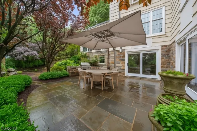 a view of a patio with table and chairs under an umbrella