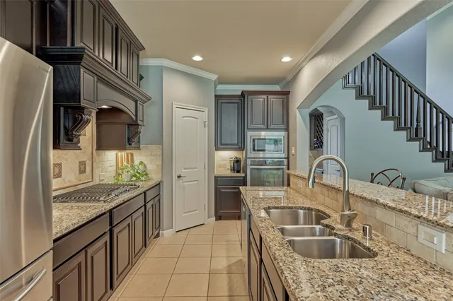 a kitchen with stainless steel appliances granite countertop a sink stove and refrigerator
