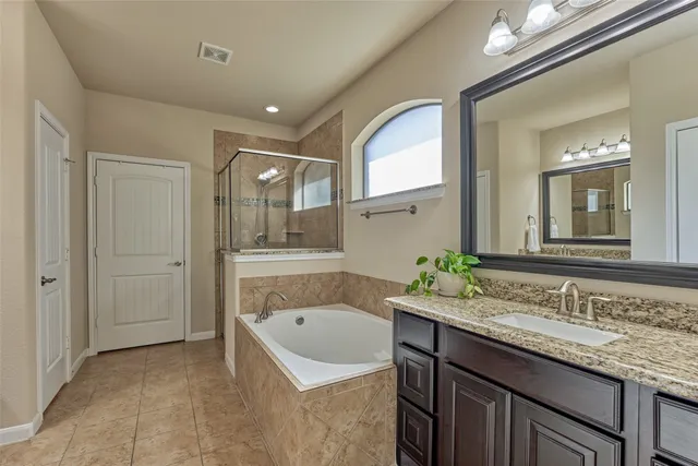 a bathroom with a granite countertop sink mirror and bathtub