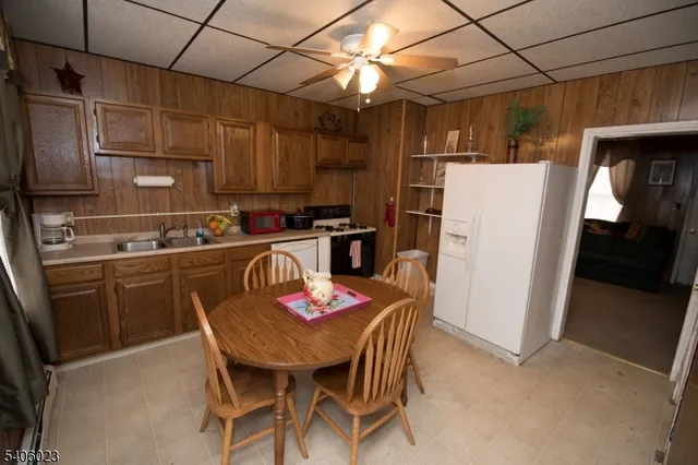 a kitchen with a refrigerator a stove a sink dishwasher and white cabinets with wooden floor