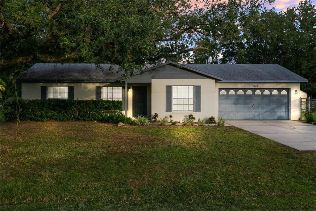 3743 Tucker Avenue St. Cloud, FL 34772 - Photo 1 of 1 a front view of a house with a yard and garage