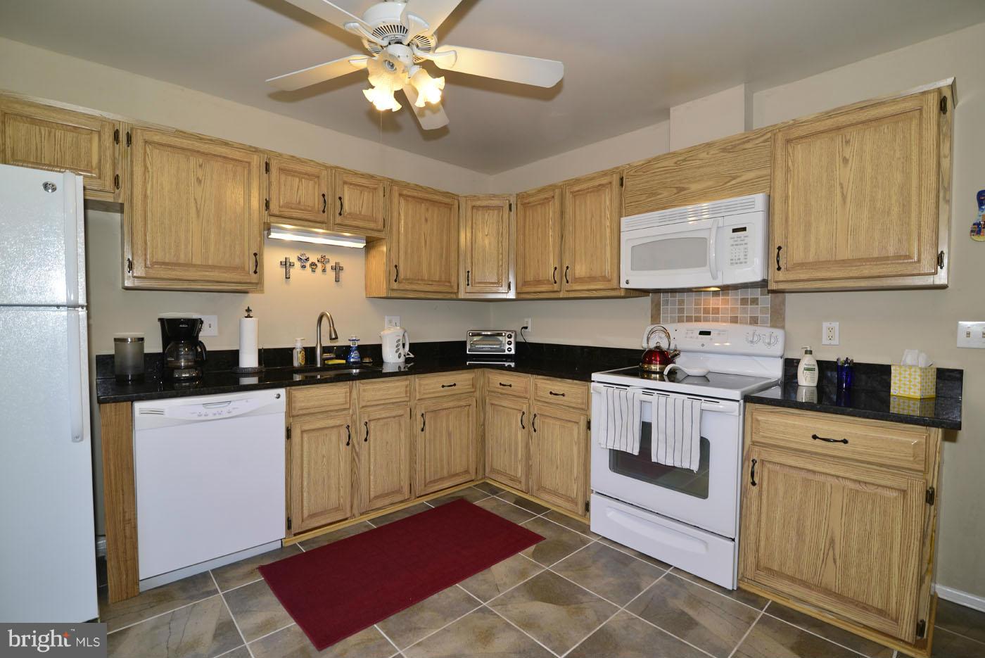 12019 Insha Court Reston, VA 20191 - Photo 6 of 27 a kitchen with stainless steel appliances granite countertop a sink and cabinets