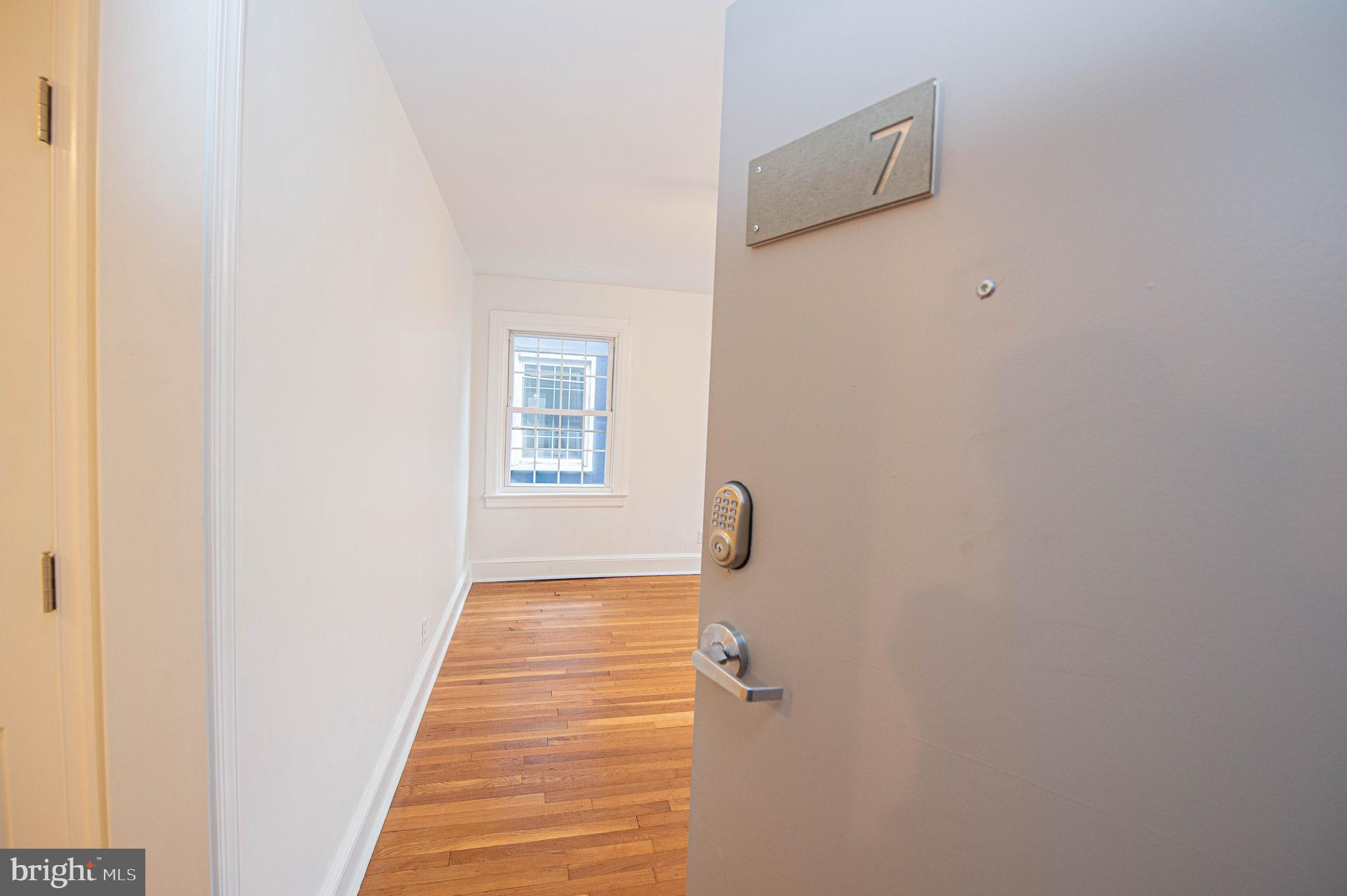 308 North Division Street, Unit 7 Salisbury, MD 21801 - Photo 14 of 56 a view of a hallway with wooden floor and a white wall