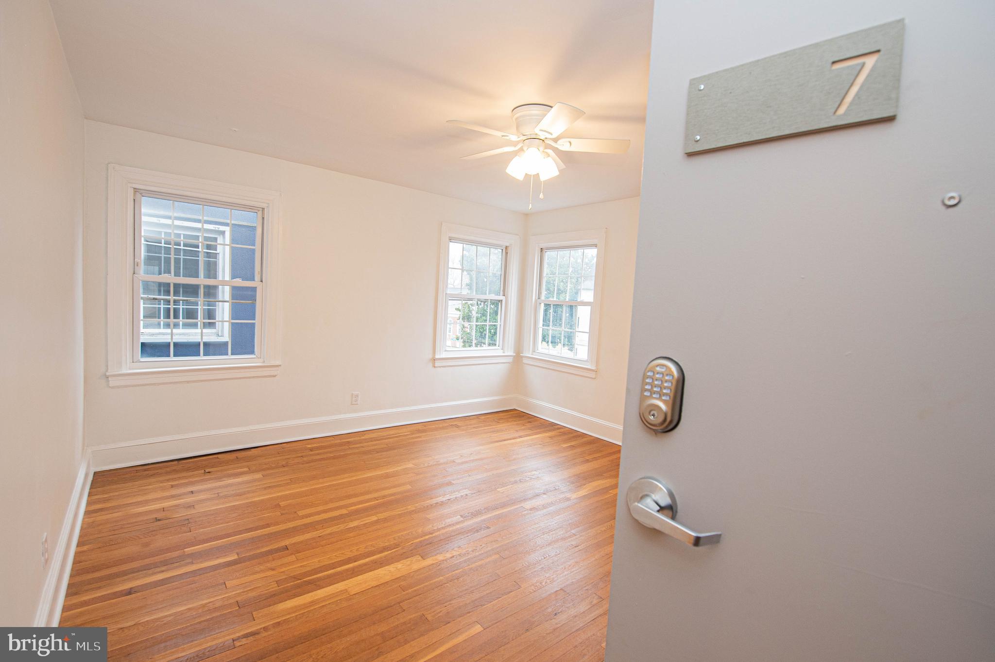 308 North Division Street, Unit 7 Salisbury, MD 21801 - Photo 15 of 56 an empty room with wooden floor fan and windows